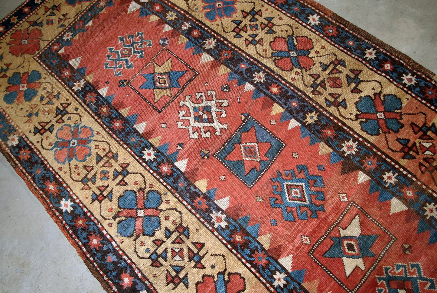 Handmade antique Caucasian Kazak rug in red and yellow shades. The rug is from the end of 19th century from Russia in original good condition.