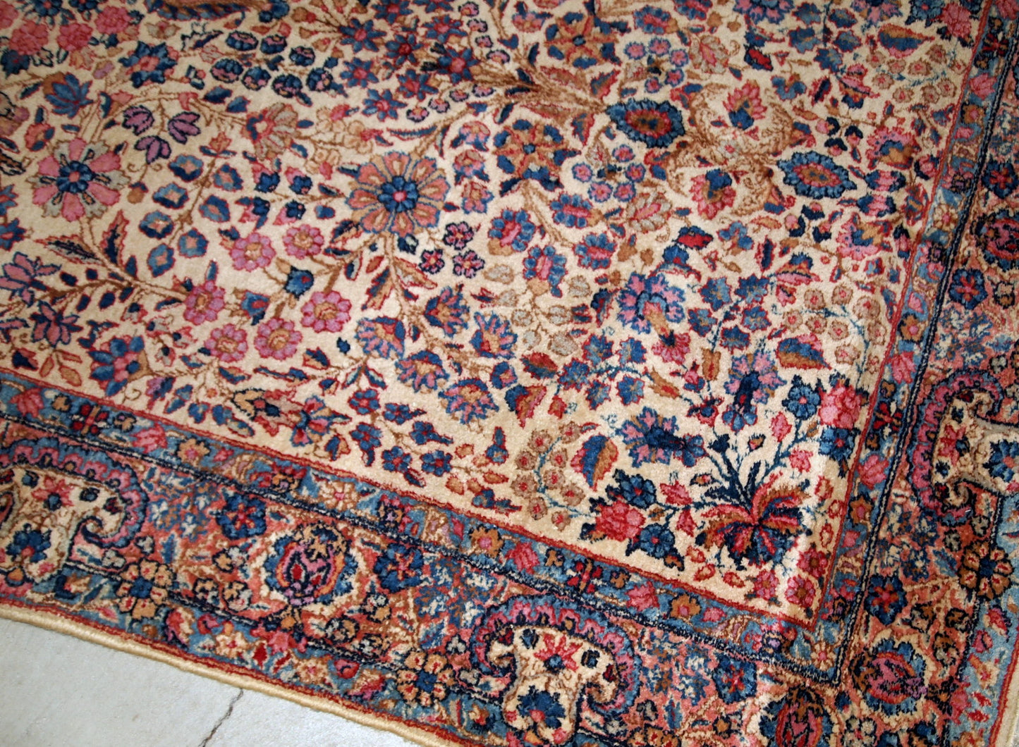 Hand-woven antique Kerman rug in original good condition, from the beginning of 20th century. The rug is in light shades and busy floral design.