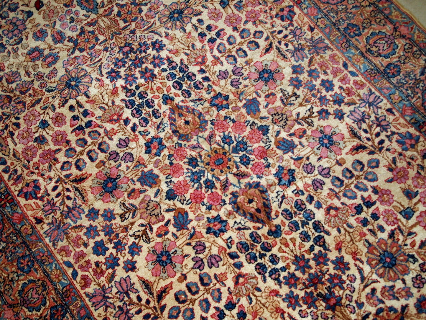 Hand-woven antique Kerman rug in original good condition, from the beginning of 20th century. The rug is in light shades and busy floral design.
