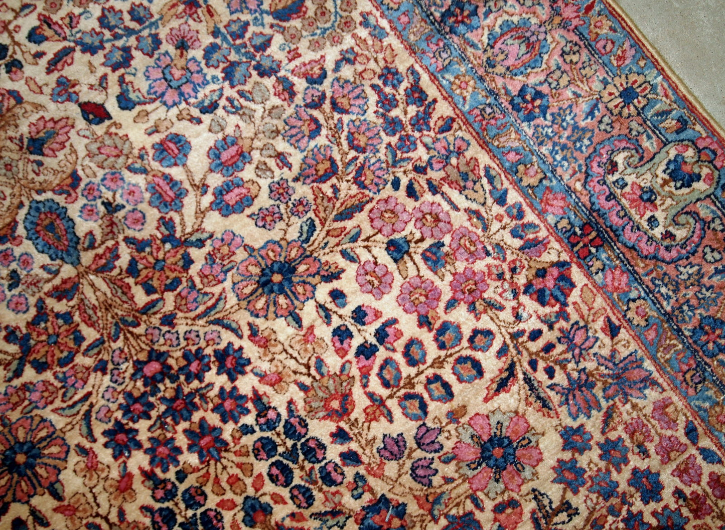 Hand-woven antique Kerman rug in original good condition, from the beginning of 20th century. The rug is in light shades and busy floral design.