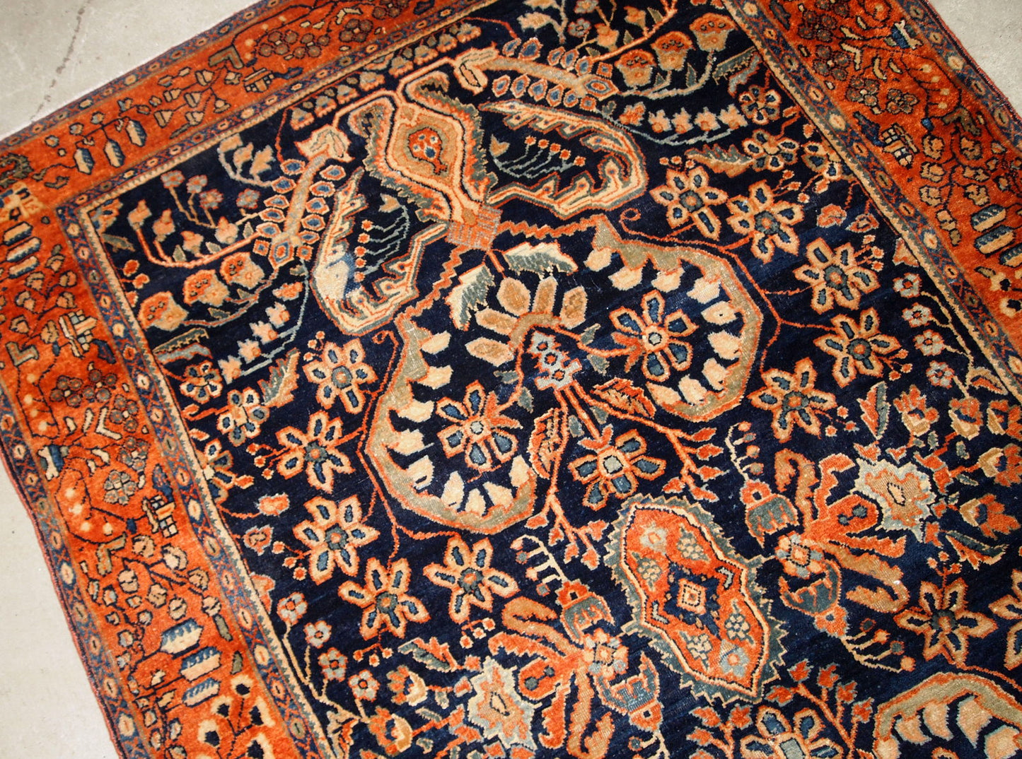 Antique hand-woven Sarouk rug in navy blue color. The rug is in original good condition, made in the beginning of 20th century.