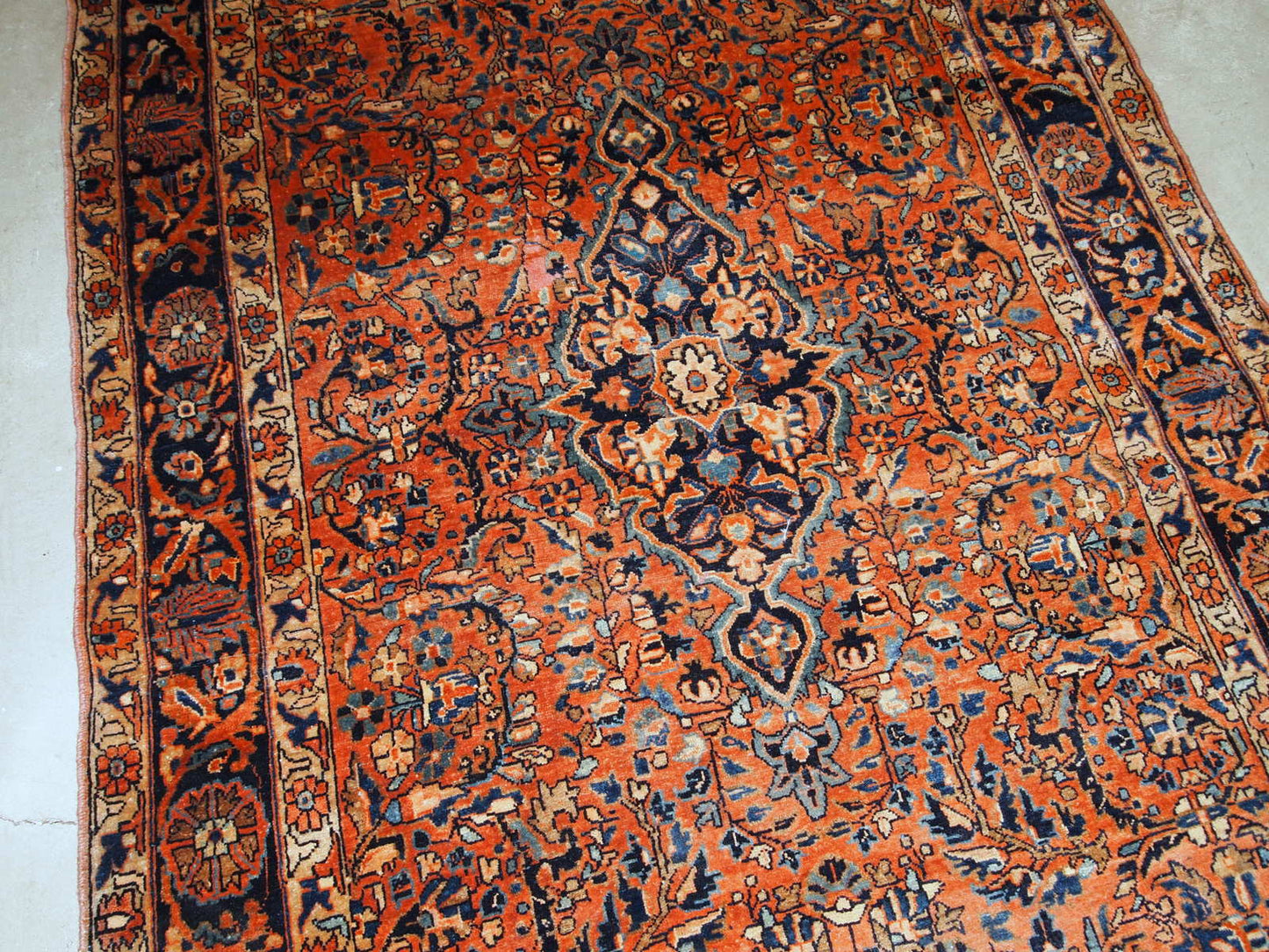 Handmade antique Sarouk rug from the beginning of 20th century. The rug is in original good condition made in red wool.