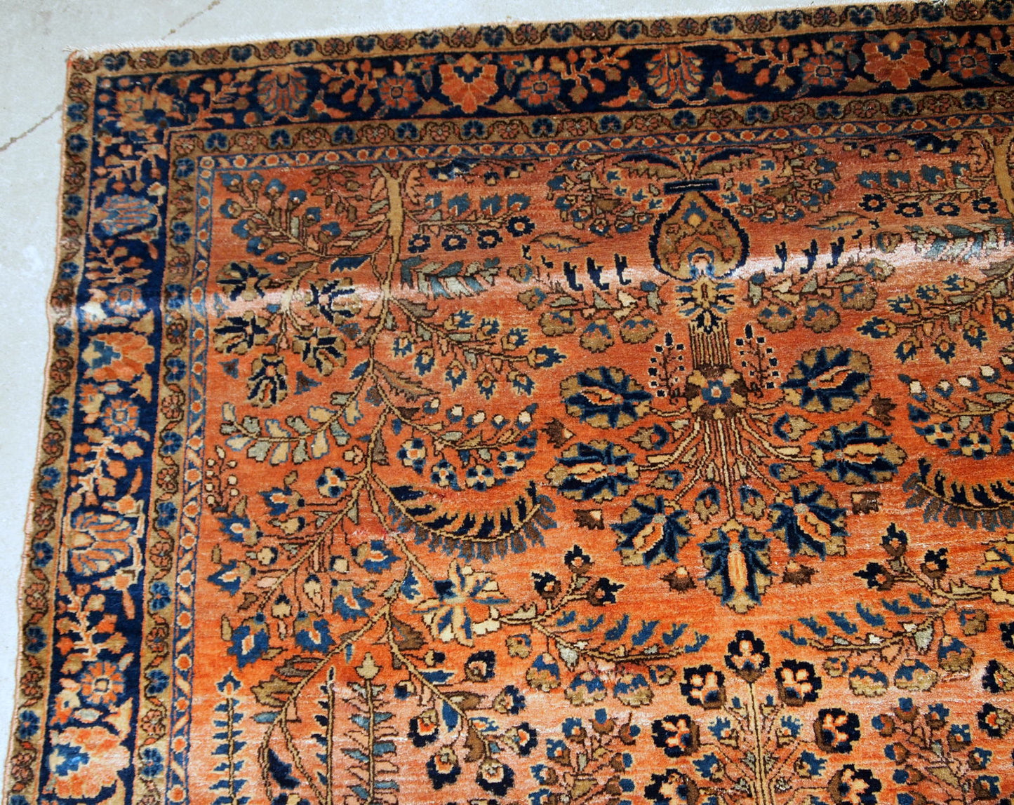 Handmade antique Sarouk rug in original good condition. The rug has been made in the beginning of 20th century in pale red wool.