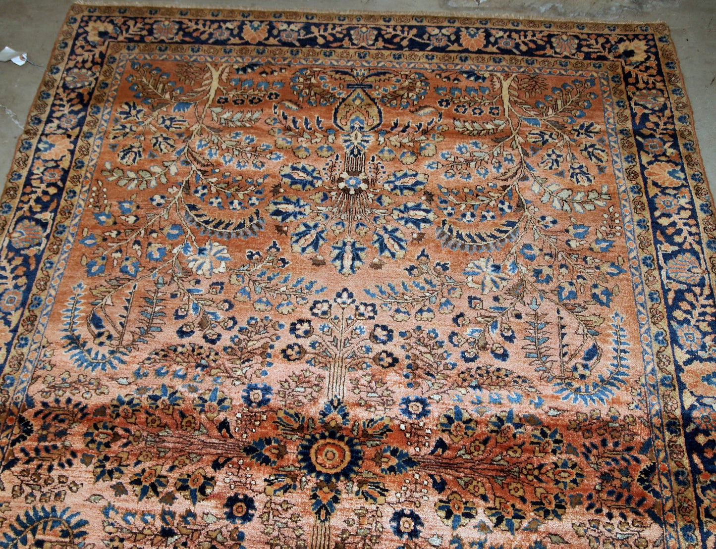 Handmade antique Sarouk rug in original good condition. The rug has been made in the beginning of 20th century in pale red wool.