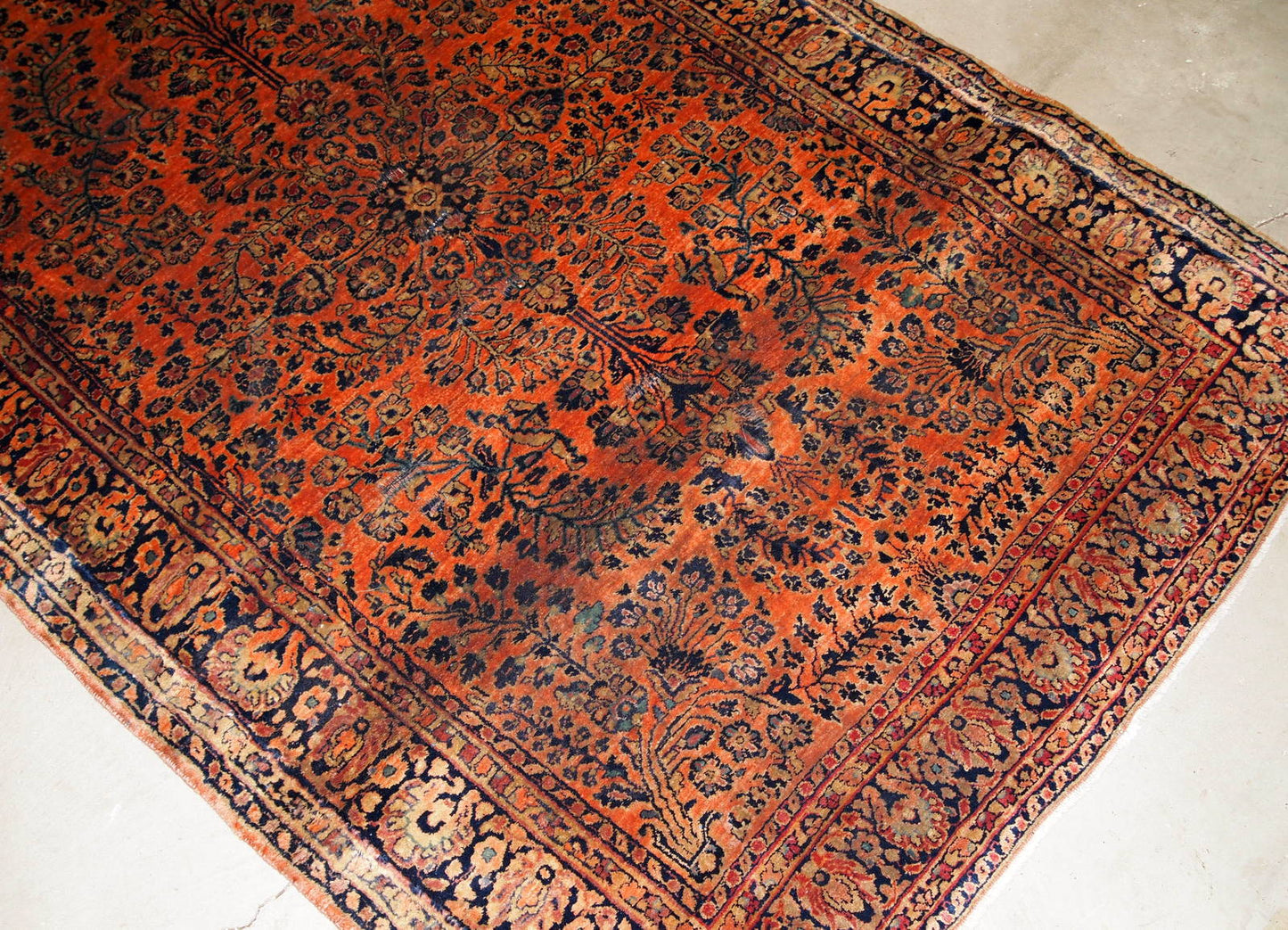 Antique handmade Persian Sarouk rug in original good condition. The rug is from the beginning of 20th century made in red wool.