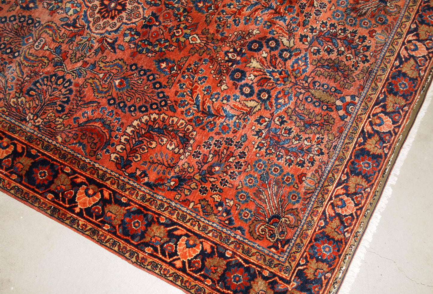 Handmade antique Sarouk rug in original good condition. The rug has been made in the beginning of 20th century in red wool.