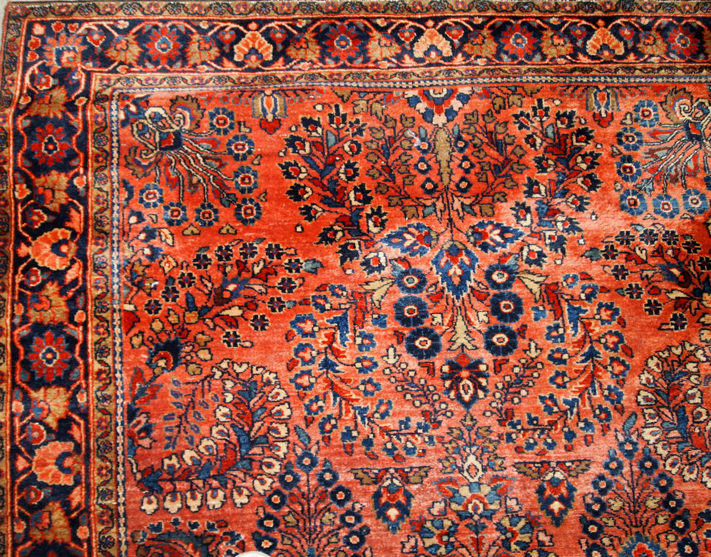 Handmade antique Sarouk rug in original good condition. The rug has been made in the beginning of 20th century in red wool.