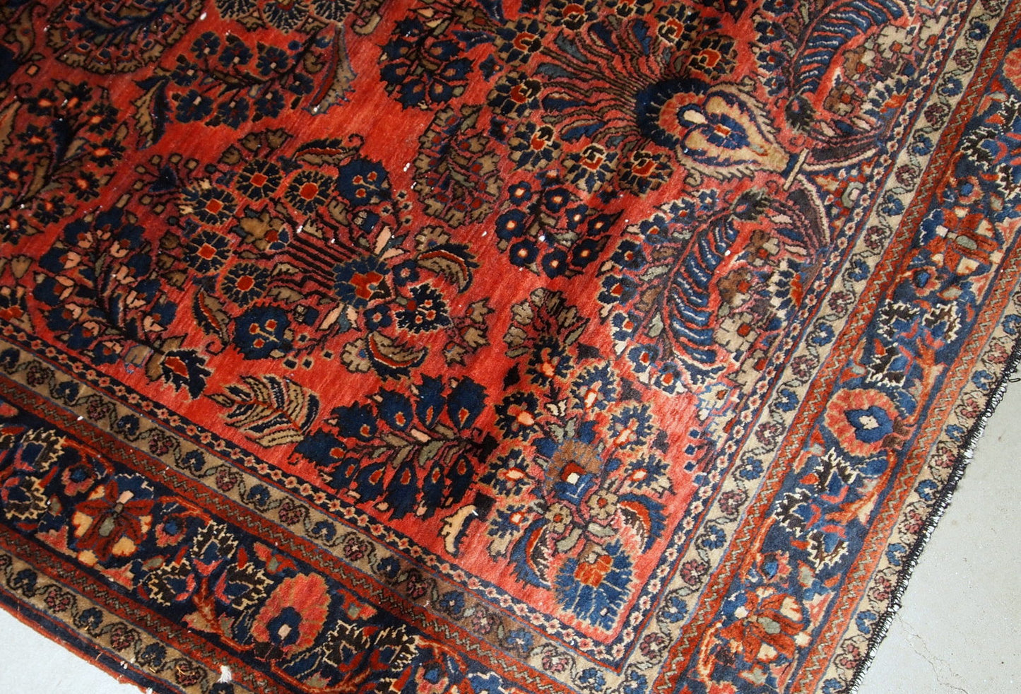Handmade antique Sarouk rug in original good condition. The rug has been made in the beginning of 20th century in red wool.