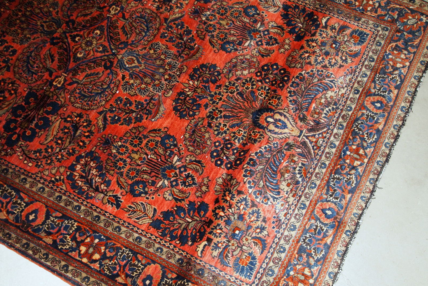 Handmade antique Sarouk rug in original good condition. The rug has been made in the beginning of 20th century in red wool.