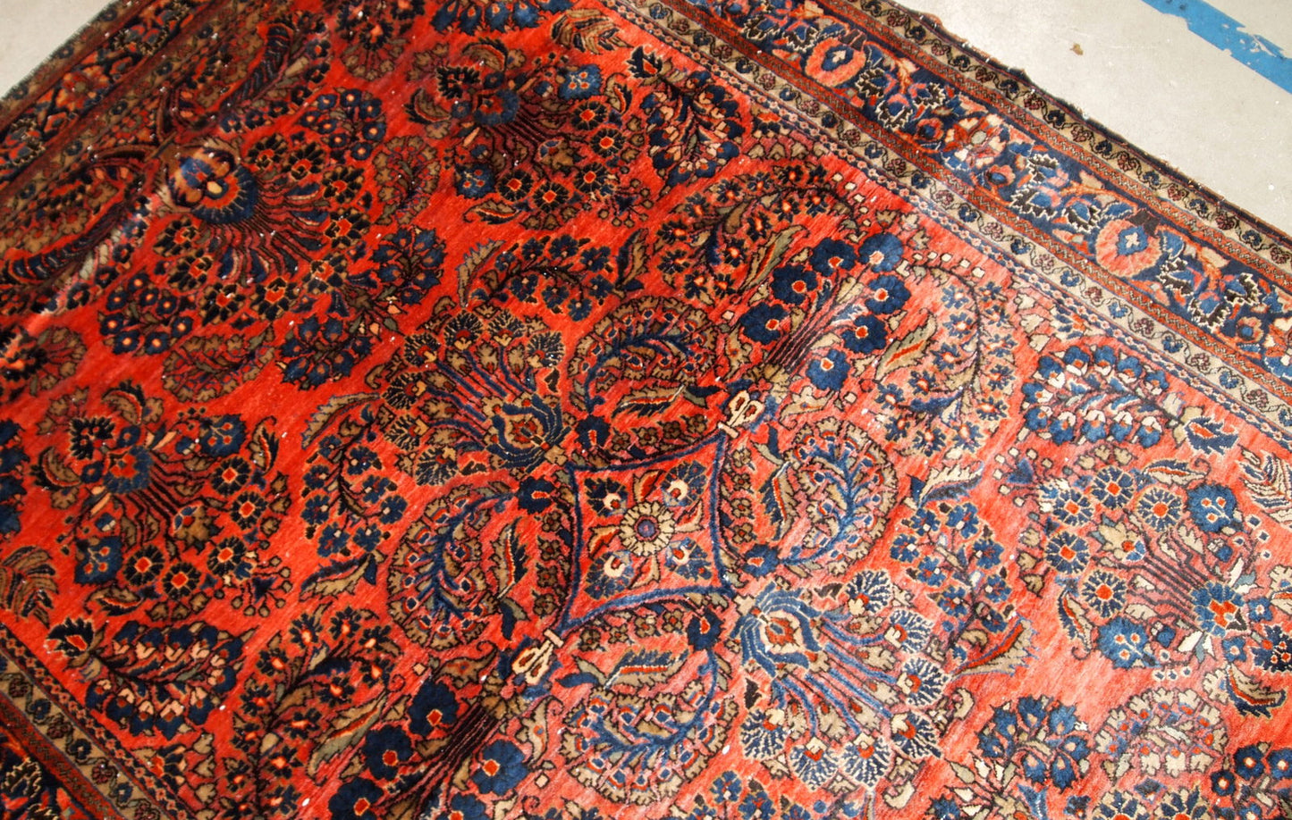 Handmade antique Sarouk rug in original good condition. The rug has been made in the beginning of 20th century in red wool.