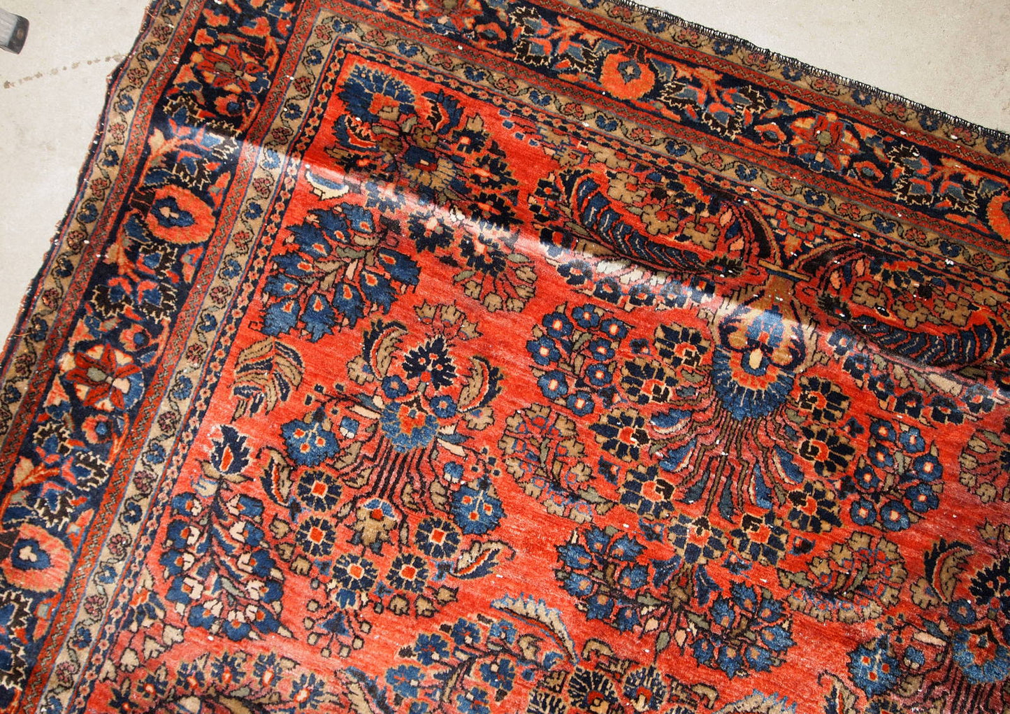 Handmade antique Sarouk rug in original good condition. The rug has been made in the beginning of 20th century in red wool.