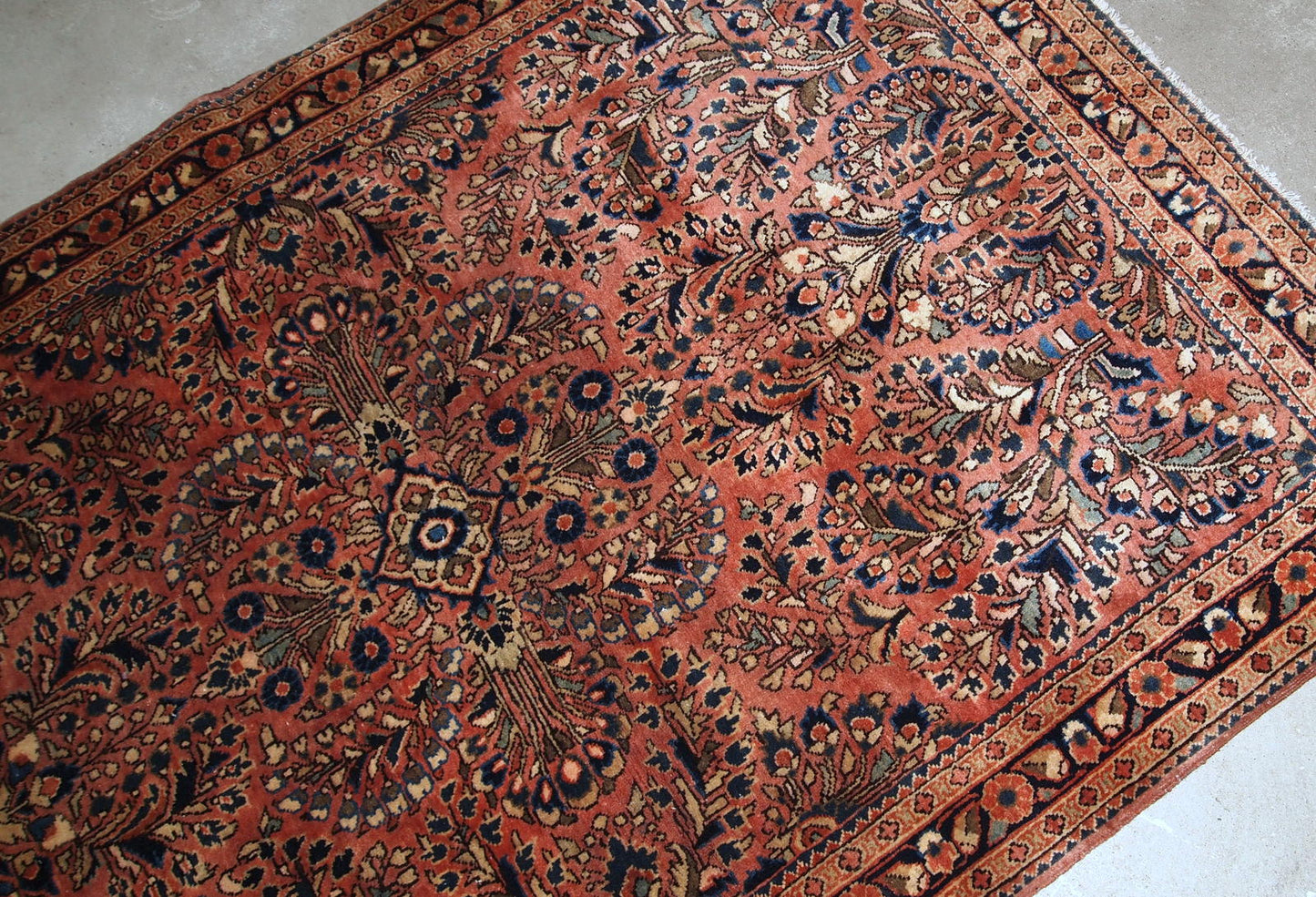 Handmade antique Persian Sarouk rug in original good condition. The rug is from the beginning of 20th century made in traditional design.