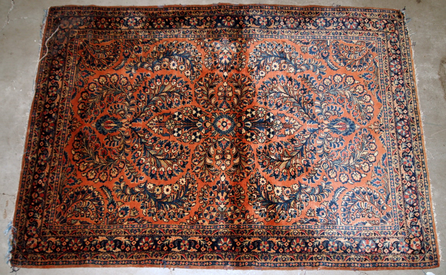 Handmade antique Persian Sarouk rug in original condition, it as some age wear on one corner. The rug is from the beginning of 20th century made in traditional floral design.