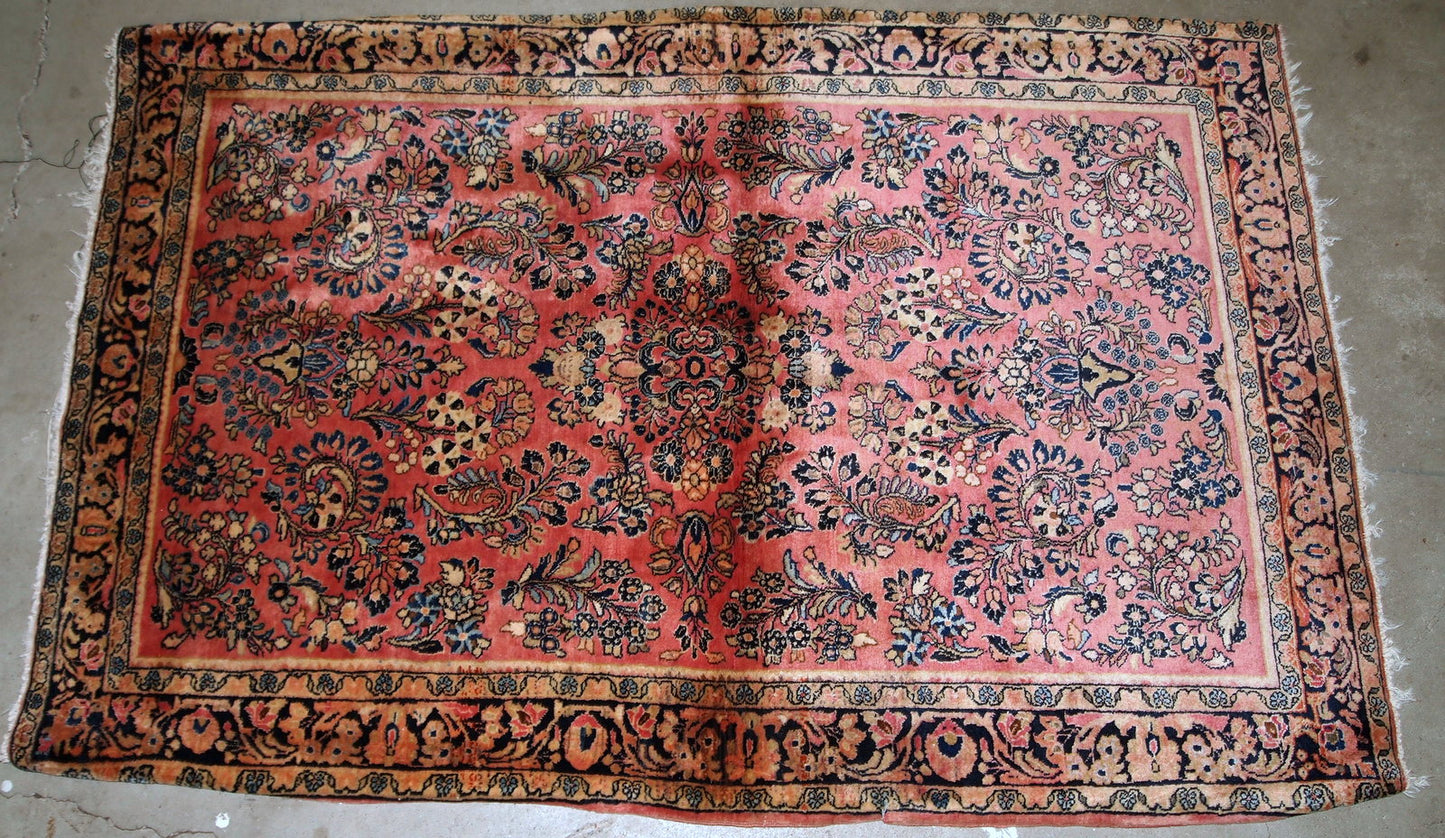 Handmade antique Persian Sarouk rug in original good condition. The rug is from the beginning of 20th century made in pink shade.