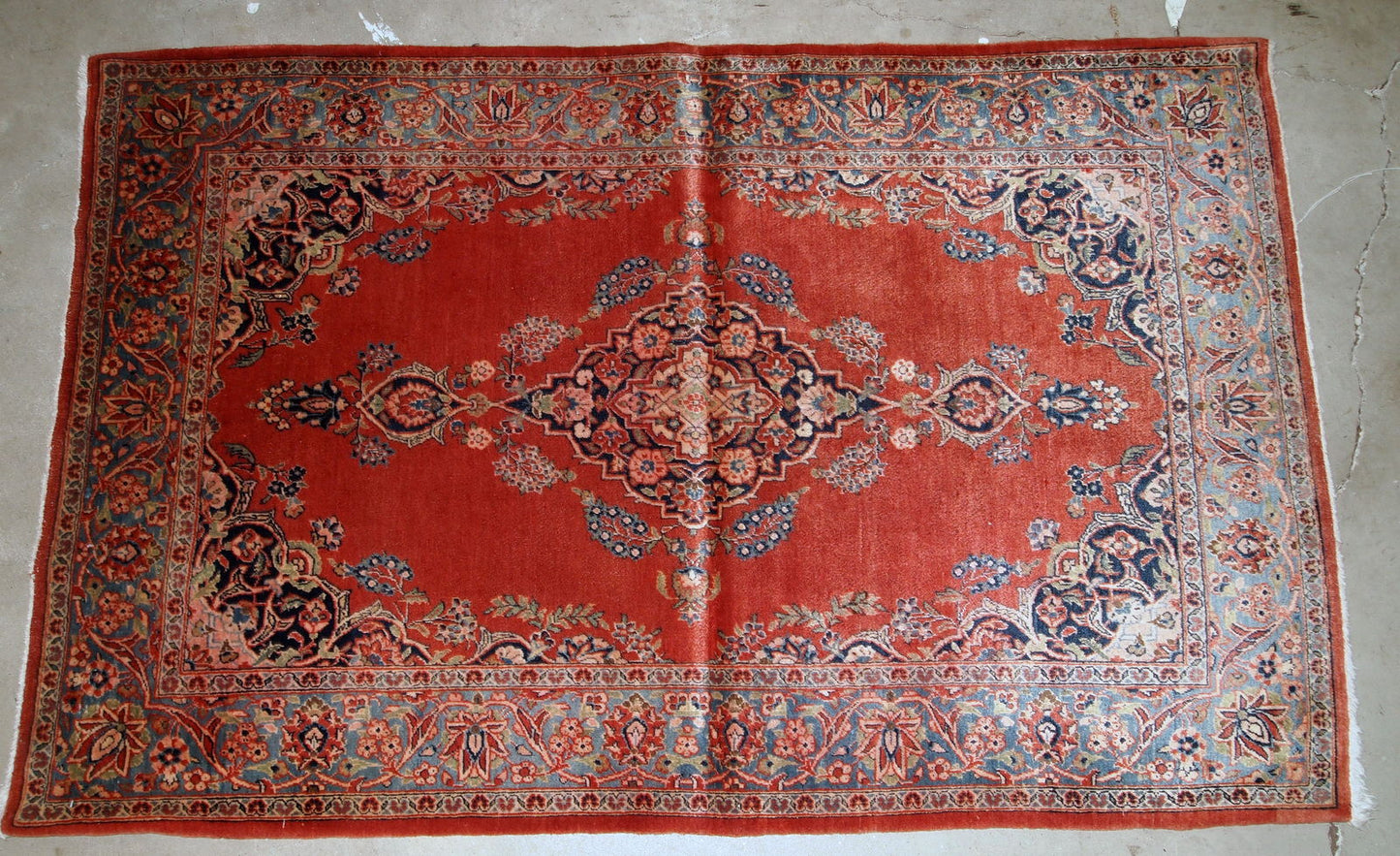 Handmade antique Persian Sarouk rug in original good condition. The rug is from the beginning of 20th century made in bright red wool.