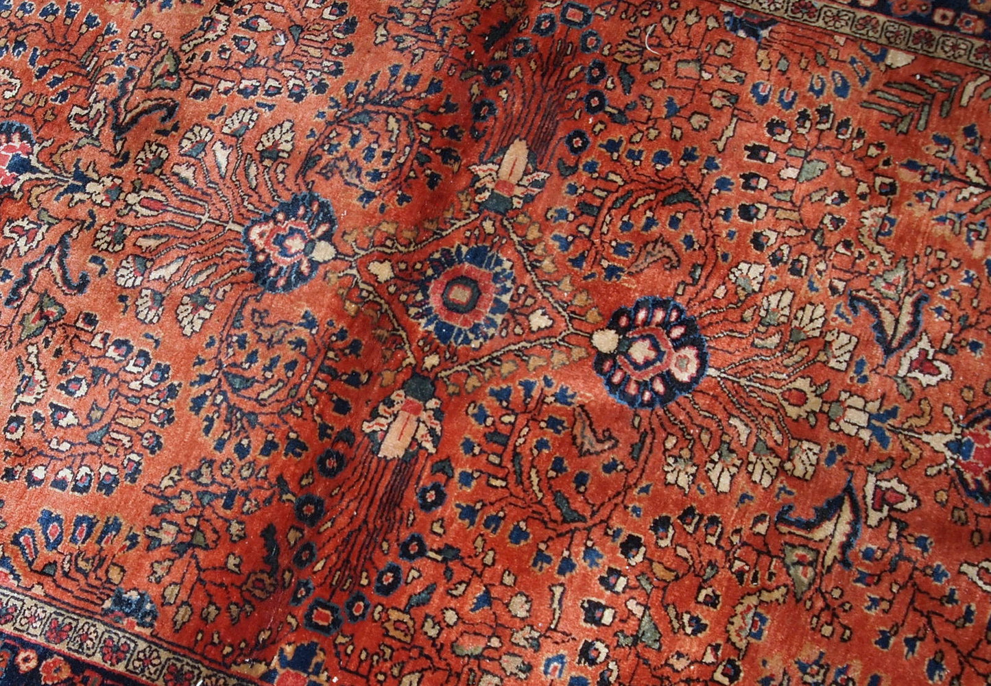 Handmade antique Persian Sarouk rug in original good condition. The rug is from the beginning of 20th century made in bright red wool.