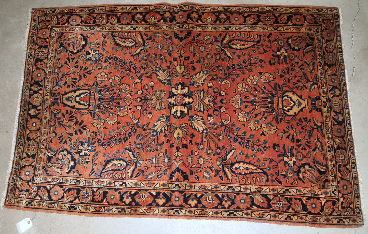 Handmade antique Persian Sarouk rug in original good condition, it has some signs of age. The rug is from the beginning of 20th century made in red wool.