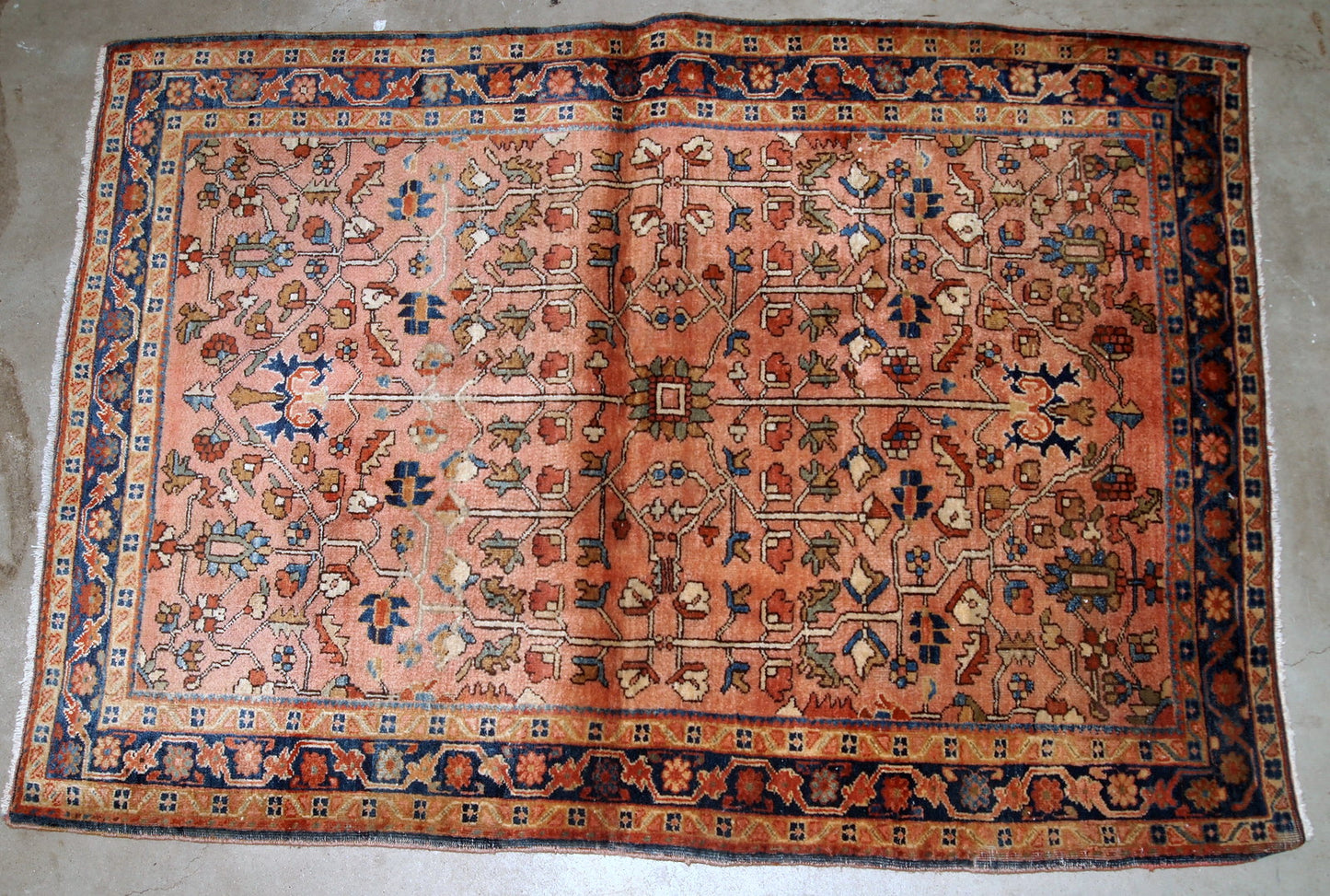 Handmade antique Persian Sarouk rug in original good condition. The rug is from the beginning of 20th century made in pale red wool and unusual design.
