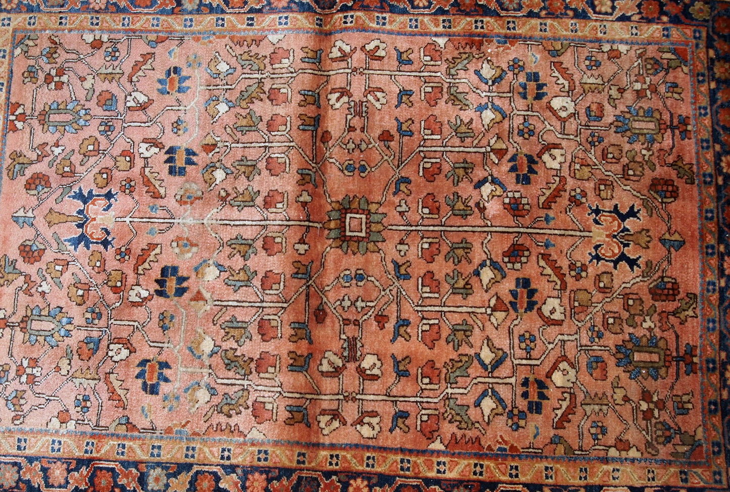 Handmade antique Persian Sarouk rug in original good condition. The rug is from the beginning of 20th century made in pale red wool and unusual design.