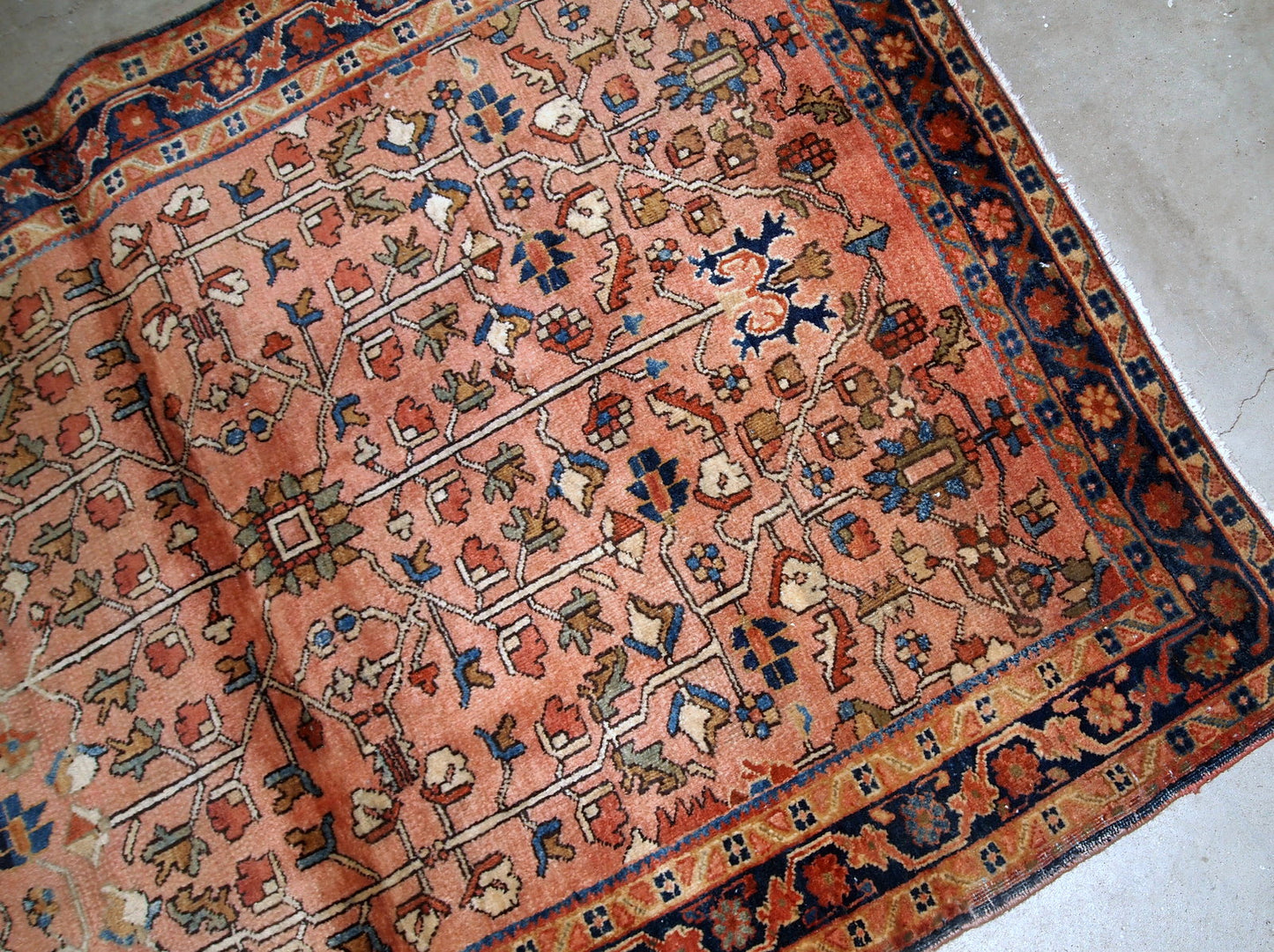 Handmade antique Persian Sarouk rug in original good condition. The rug is from the beginning of 20th century made in pale red wool and unusual design.
