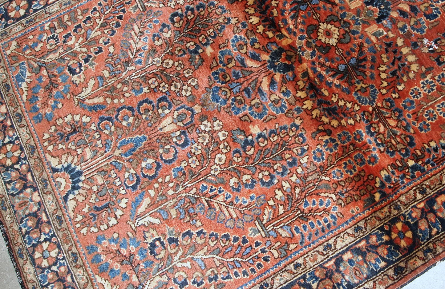 Handmade antique Persian Sarouk rug in original good condition. The rug is from the beginning of 20th century made in red wool.