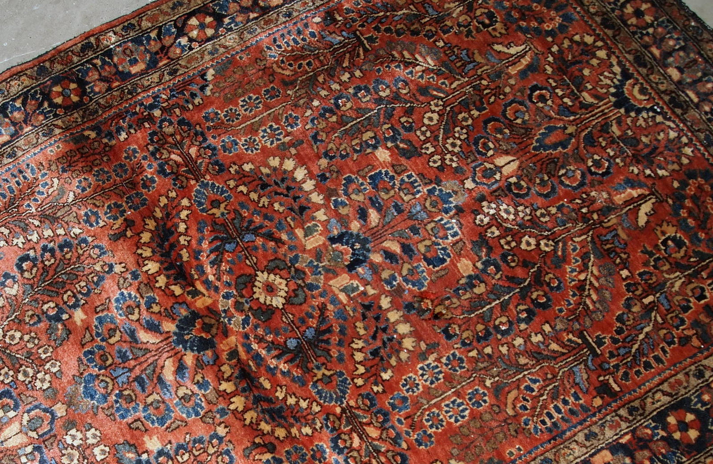 Handmade antique Persian Sarouk rug in original good condition. The rug is from the beginning of 20th century made in red wool.