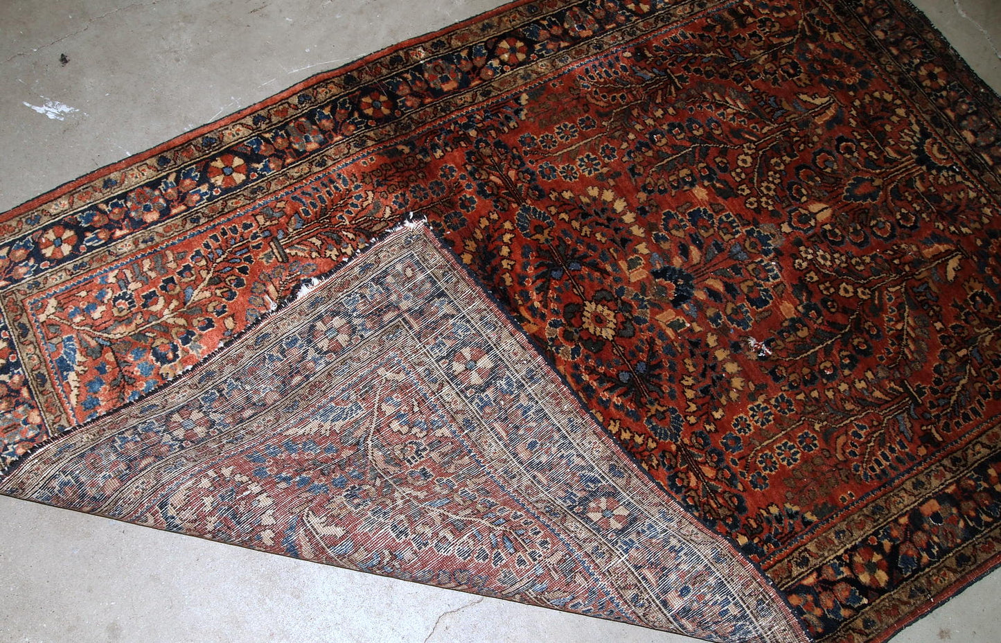 Handmade antique Persian Sarouk rug in original good condition. The rug is from the beginning of 20th century made in red wool.