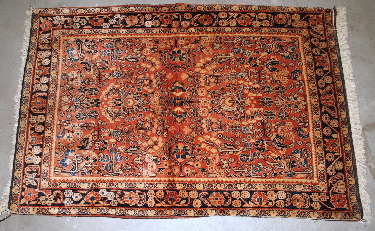 Handmade antique Persian Sarouk rug in original good condition. The rug is from the beginning of 20th century made in red wool.