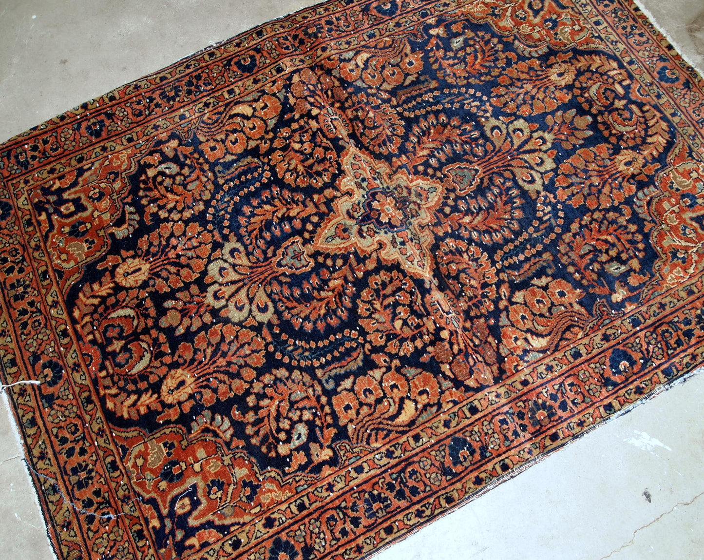 Handmade antique Persian Sarouk rug in original condition, it has some signs of age. The rug is from the beginning of 20th century made in red wool.