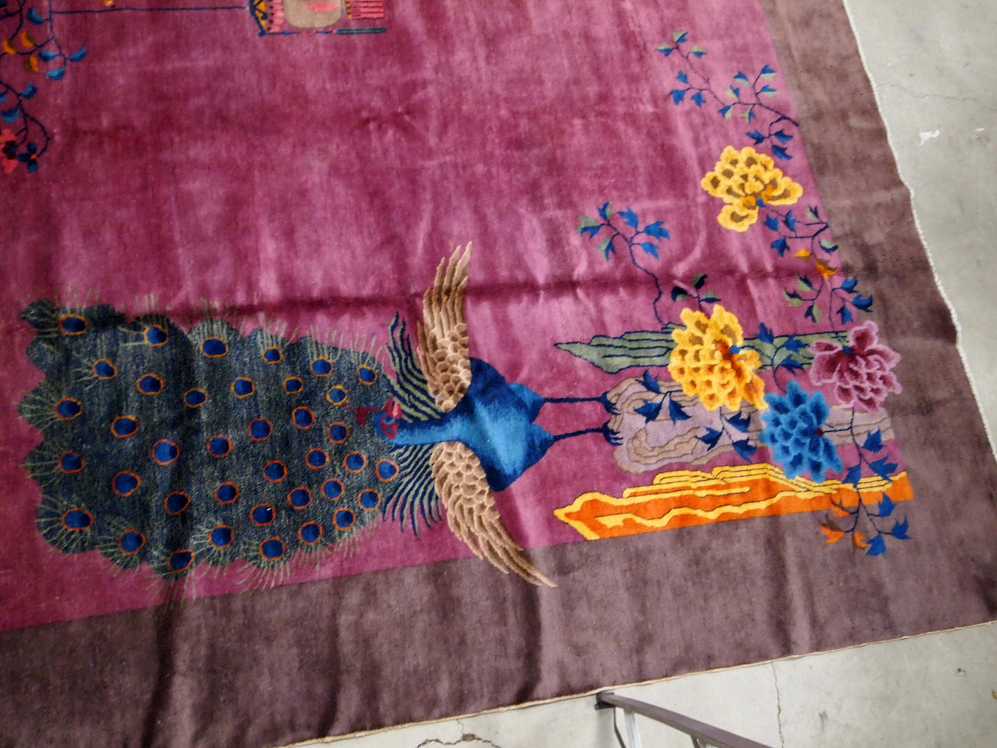 Handmade antique Art Deco Chinese rug in ruby and burgundy shades. The rug is from the beginning of 20th century in original good condition. It has some floral accent with large peacock on it.