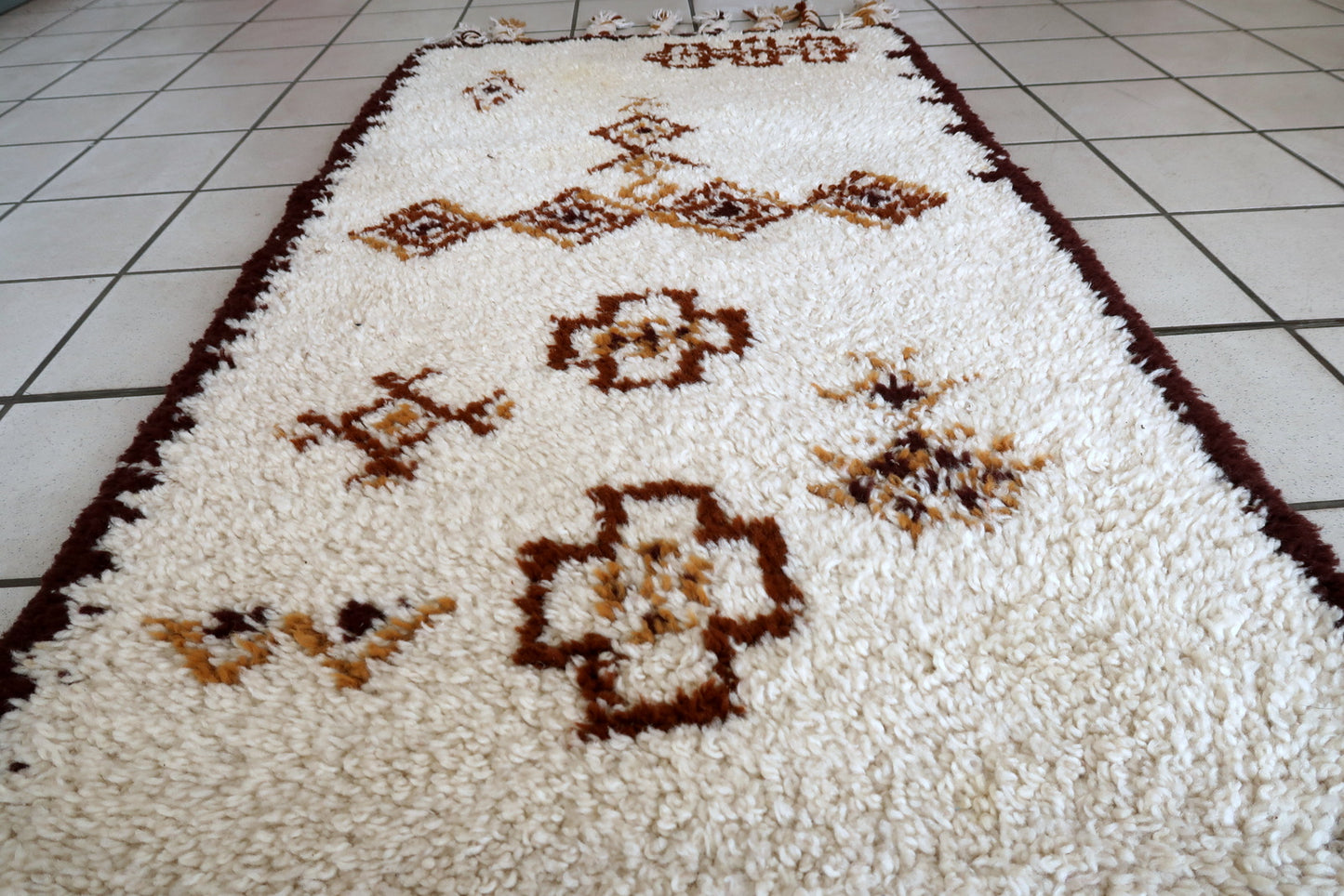 Handmade vintage Moroccan Berber woolen rug in white and brown colors. The rug is from the end of 20th century in original good condition.