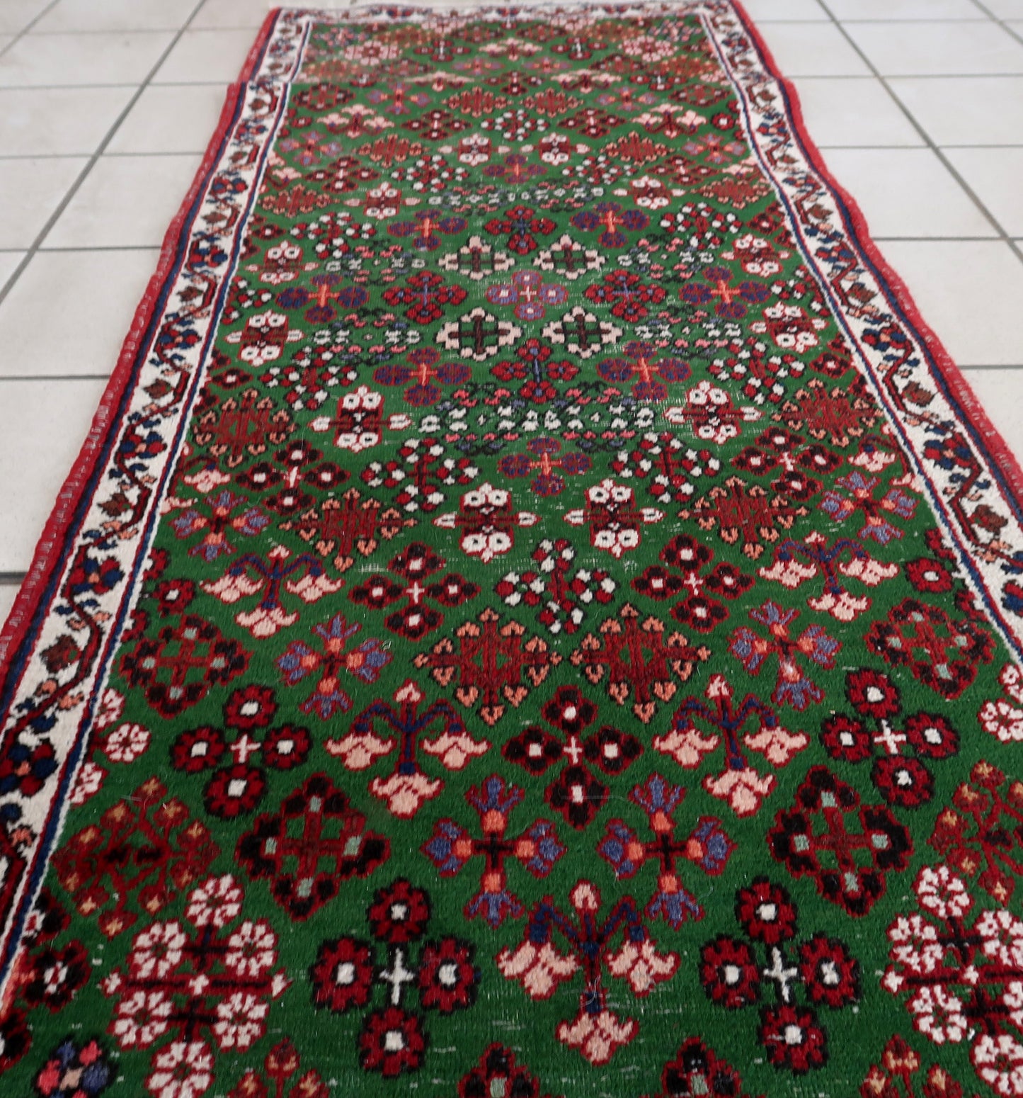 Handmade antique Persian Joshagan runner in green color. The runner is from the beginning of 20th century in original condition, it has some low pile.