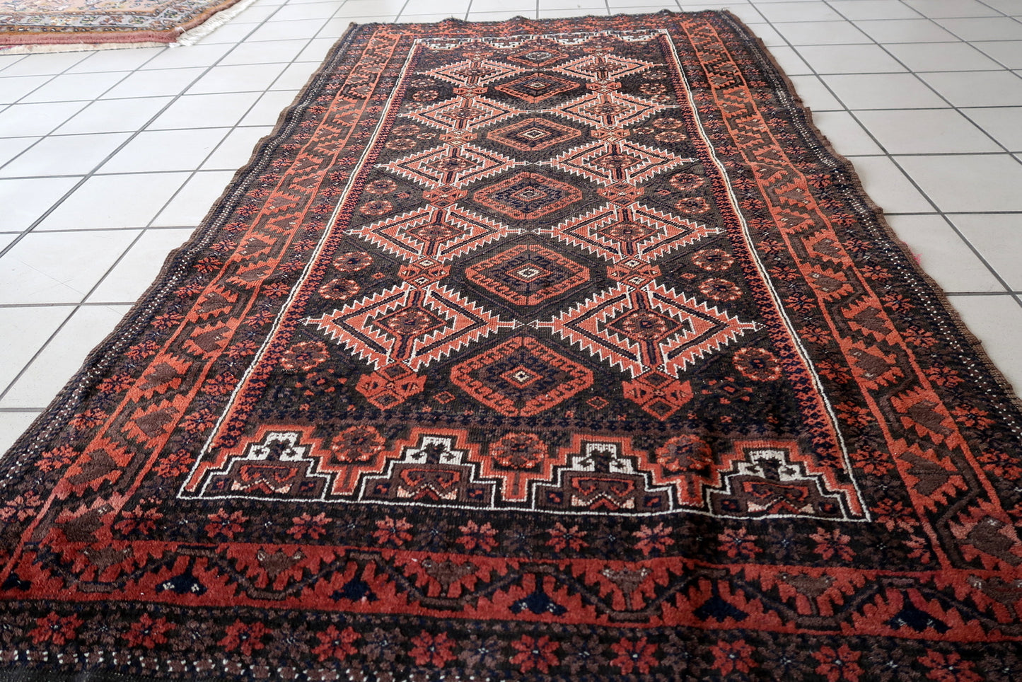 Handmade antique Afghan Baluch rug in traditional tribal design. The rug is from the beginning of 20th century in original condition, it yhas some minimal low pile.