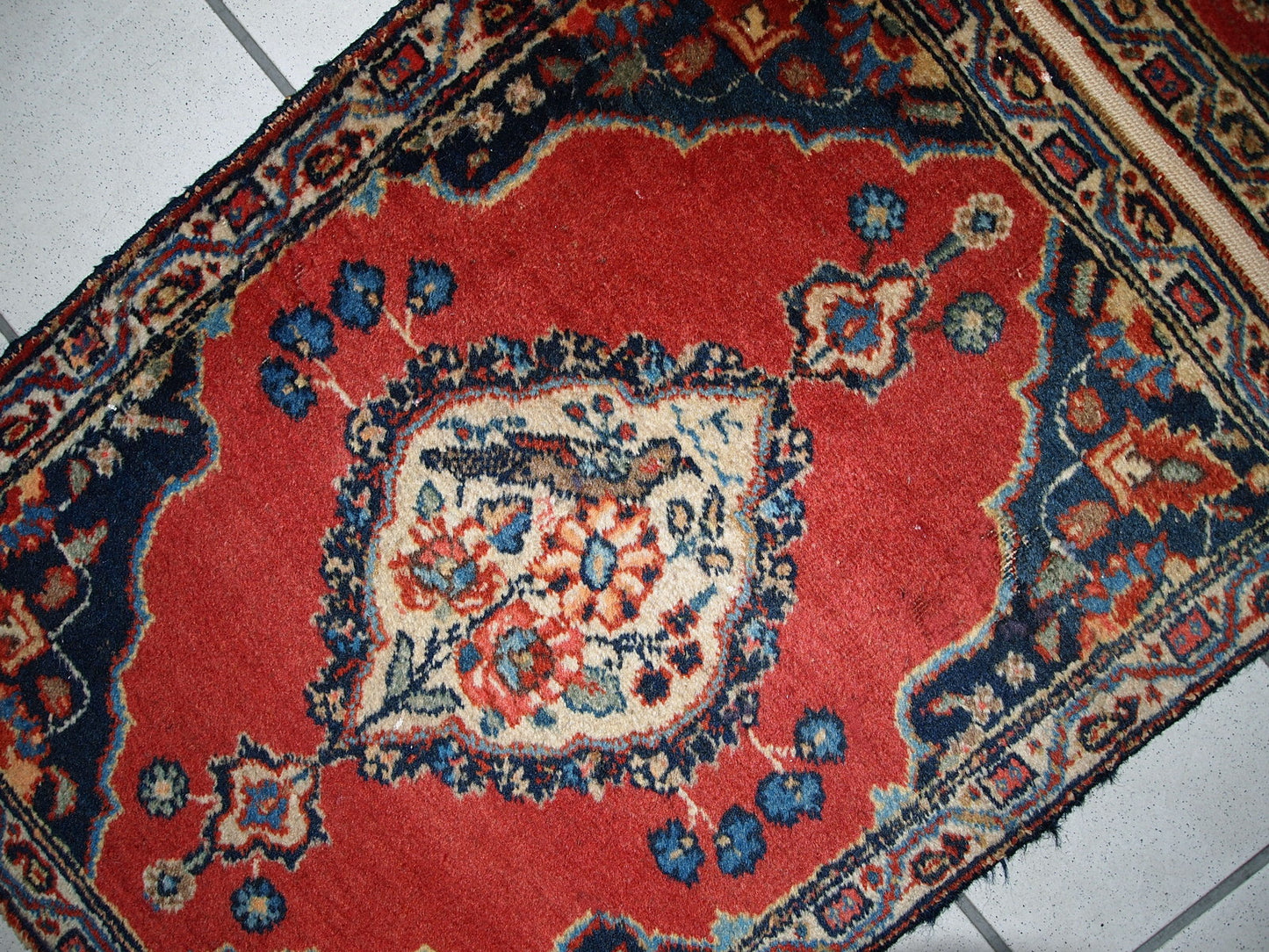 Antique Tabriz double mat in original good condition, one of the rugs has some low pile. The design is traditional with decorative birds in the center.