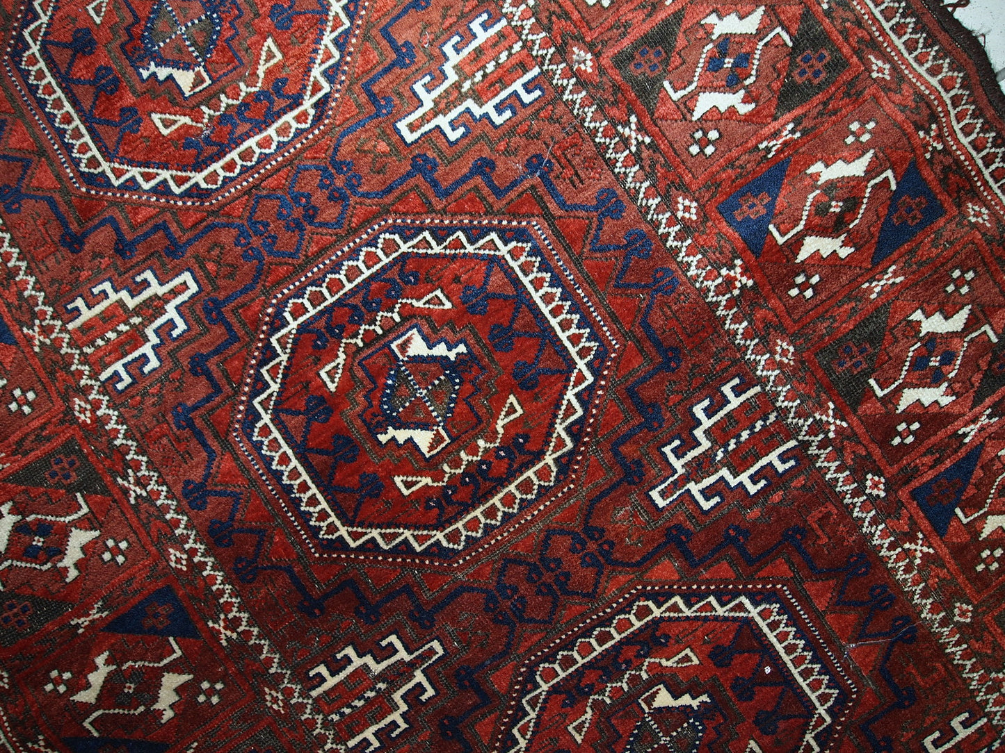 Antique hand made Afghan Baluch rug in original condition, has some age wear. The rug is in traditional deep burgundy shade with navy blue and white accents, has very rich combination of colors.