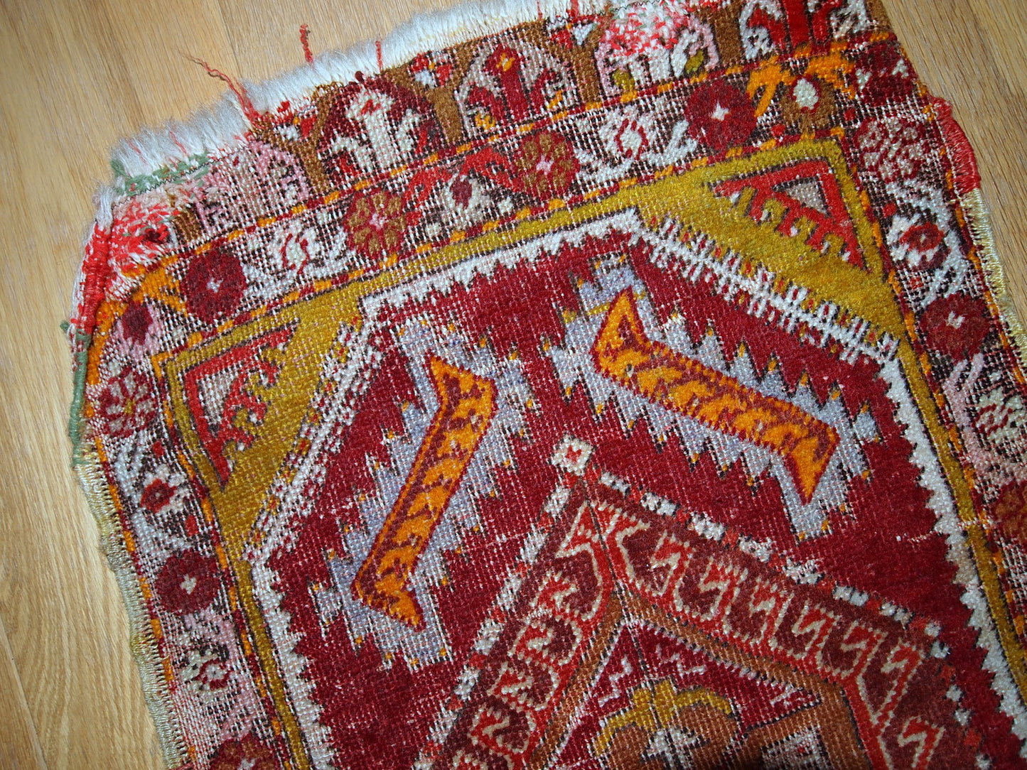 Antique Turkish Yastik rug in distressed condition. The rug made in red color with some accents of gold, orange and olive brown shades.