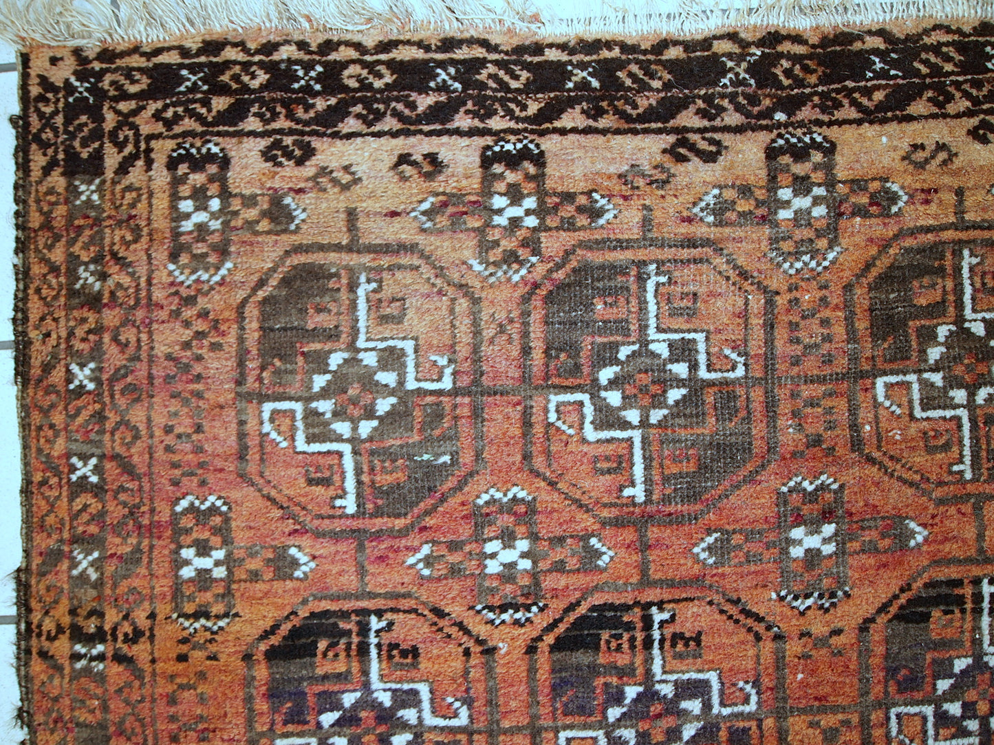 Antique hand made Afghan Baluch rug in original good condition. This rug is in brick red shade with repeating design.