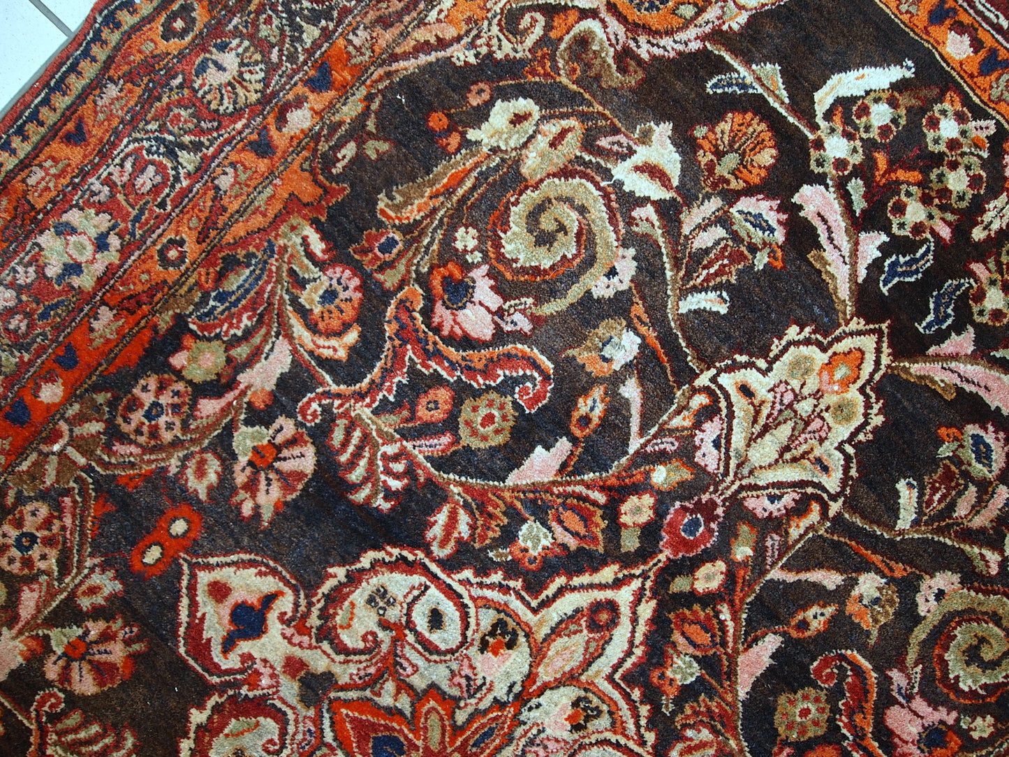 Vintage Persian Tabriz rug in original good condition. It is in chocolate brown and orange wool with some olive and pink shades.