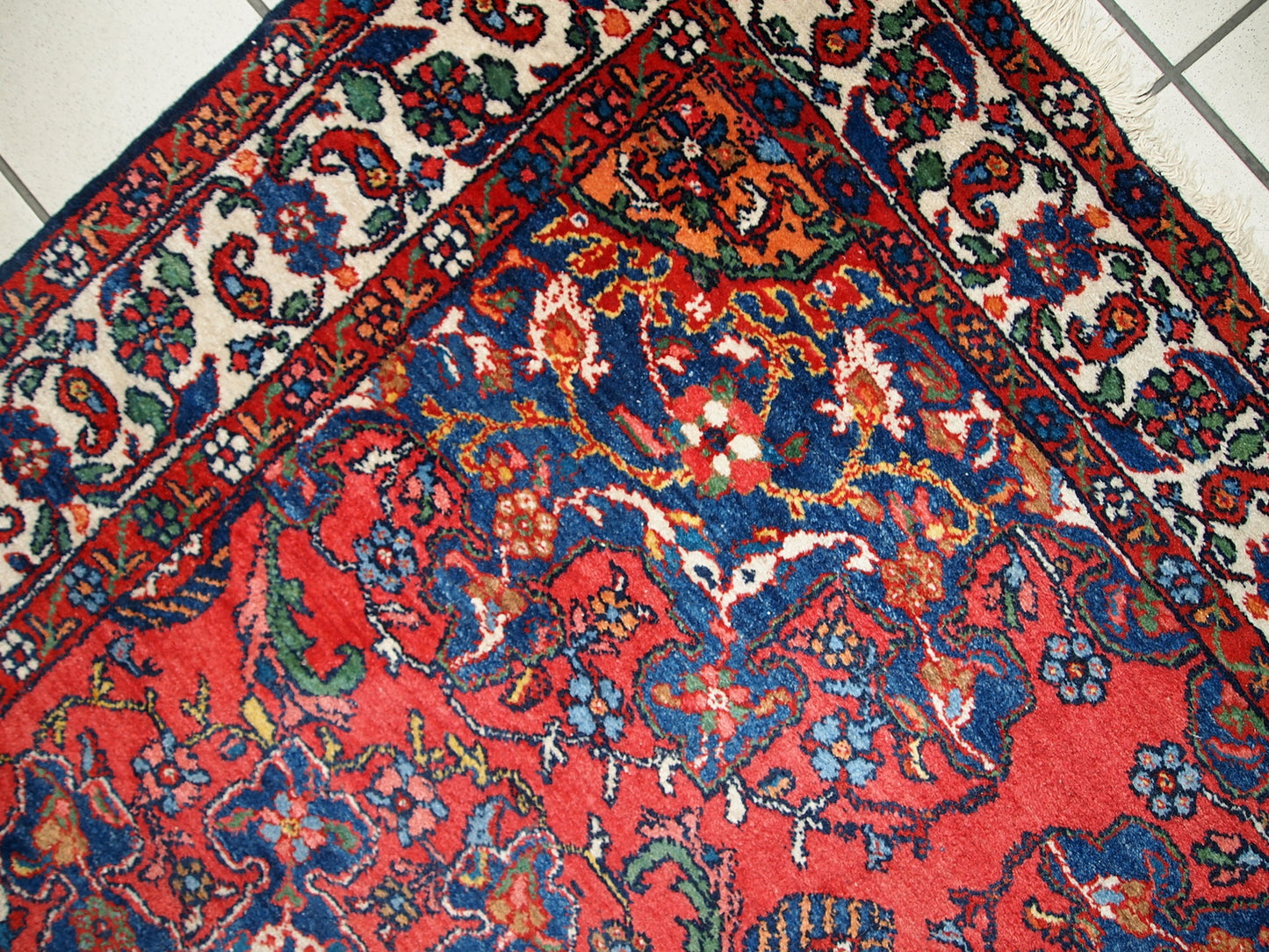 Vintage Persian Mashad rug in original good condition. It has been hand-weaved in the end of 20th century in wool.