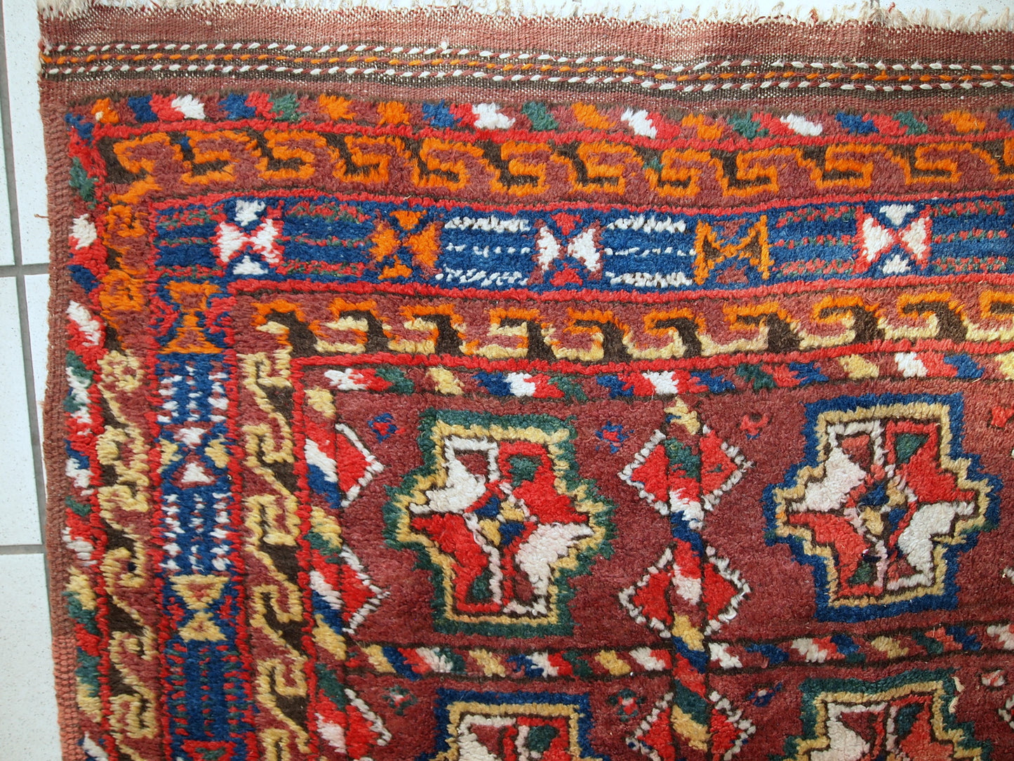 This antique Kurdish rug made in deep shade of burgundy. All-over design with geometric and tribal accents. The wool on the rug is soft, it is in original good condition.
