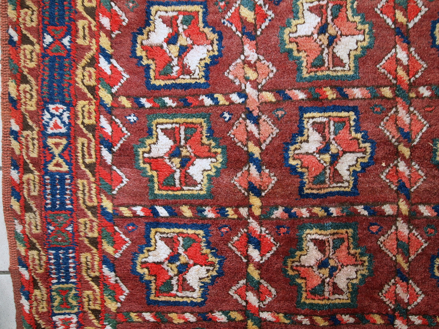 This antique Kurdish rug made in deep shade of burgundy. All-over design with geometric and tribal accents. The wool on the rug is soft, it is in original good condition.