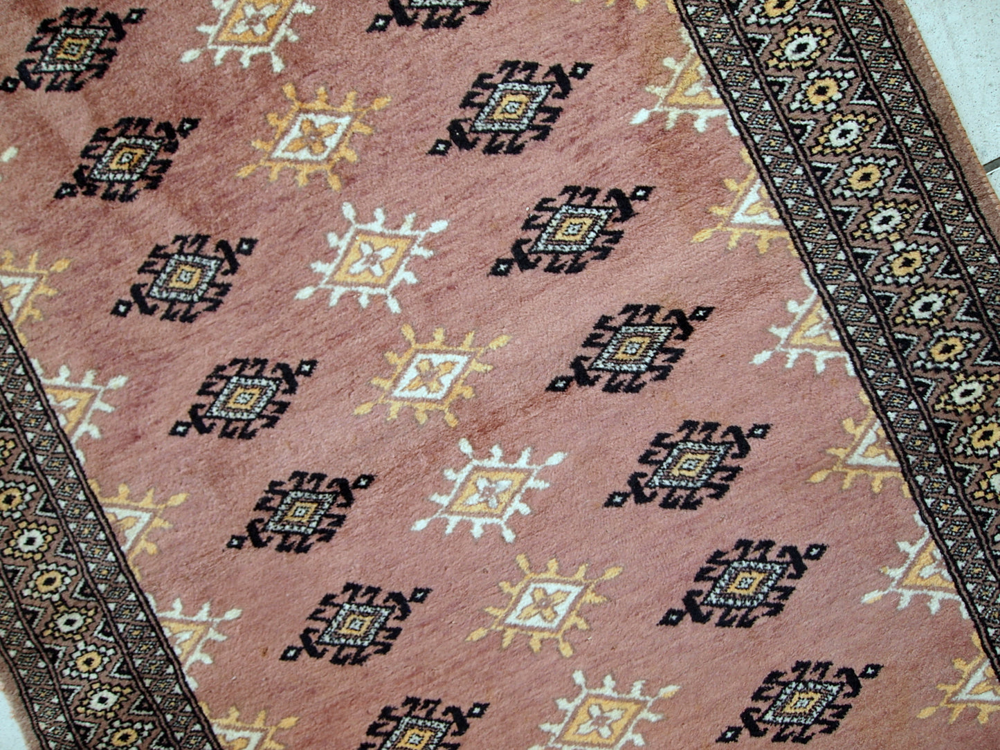 Handmade vintage Uzbek Bukhara rug in original good condition. The rug made in soft wool of peach shade.