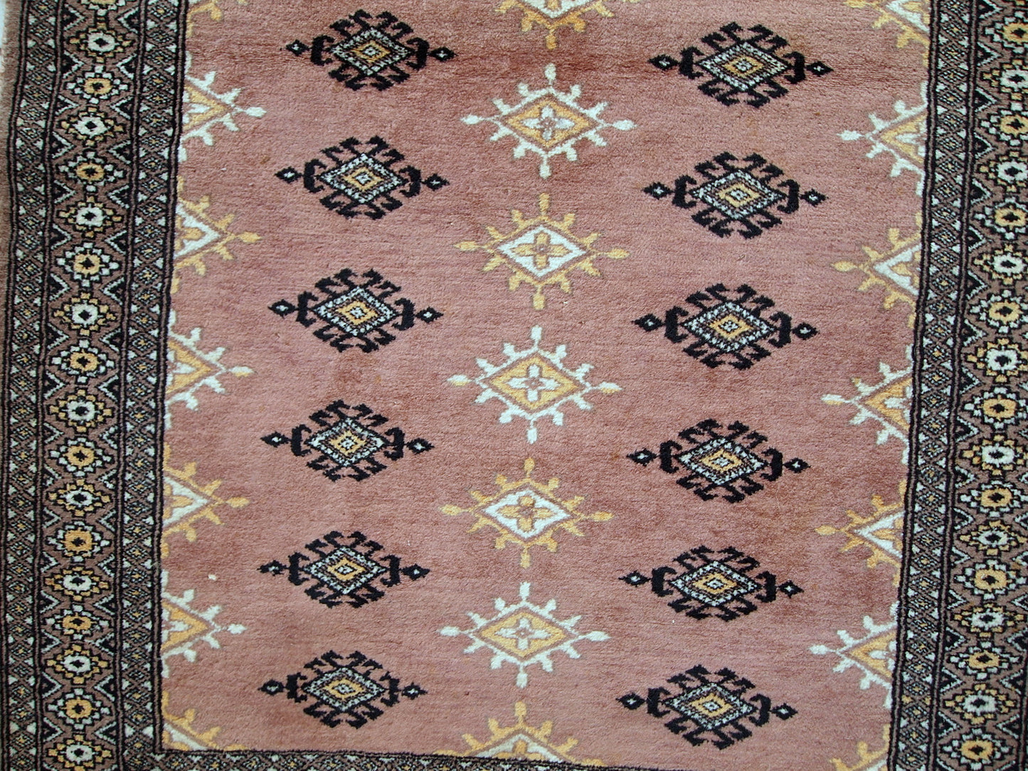 Handmade vintage Uzbek Bukhara rug in original good condition. The rug made in soft wool of peach shade.