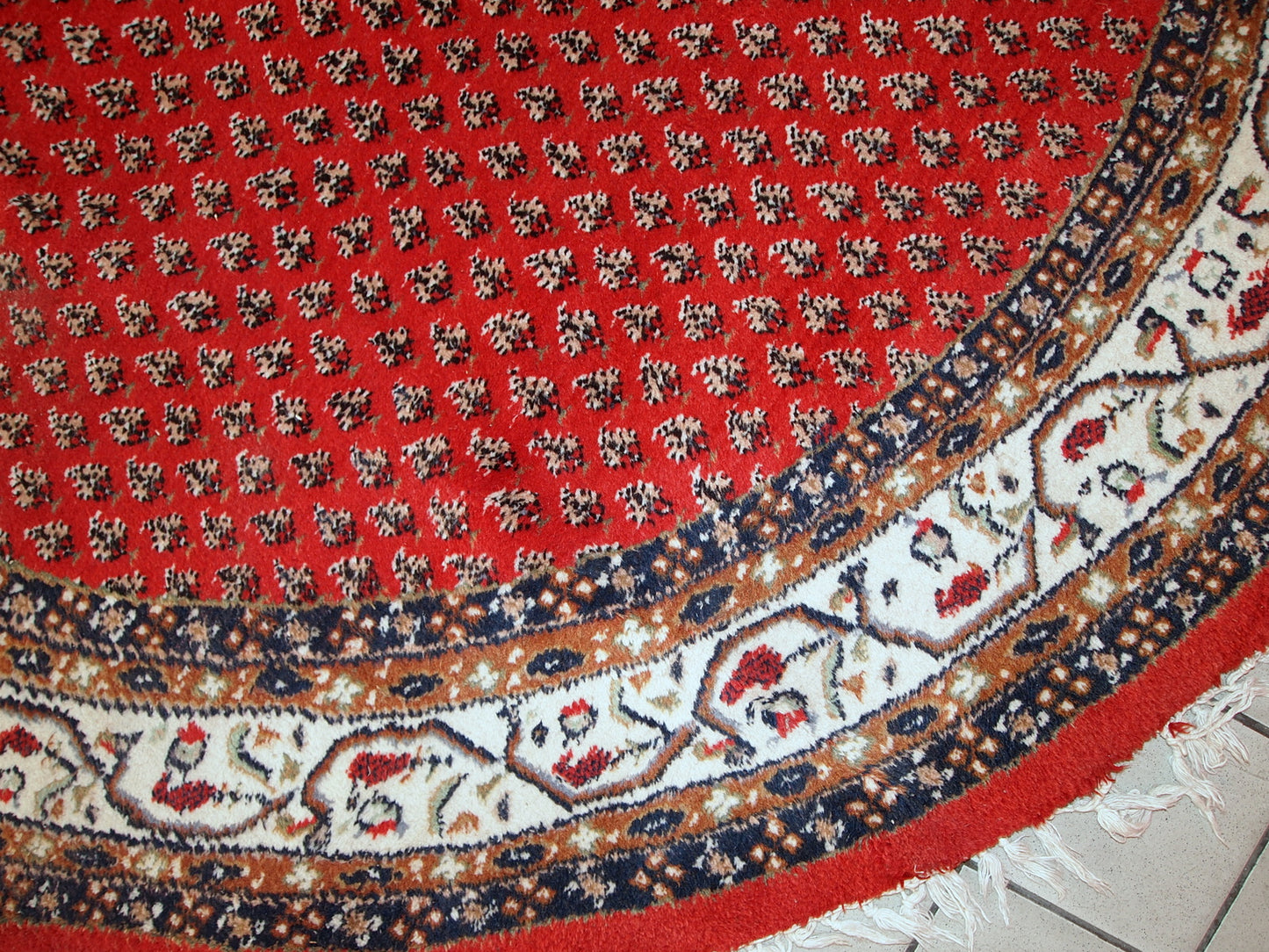 Vintage handmade Indian rug with Persian Seraband design in red with white border. All-over design with repeating pattern. The rug is from the end of 20th century in original good condition. 
