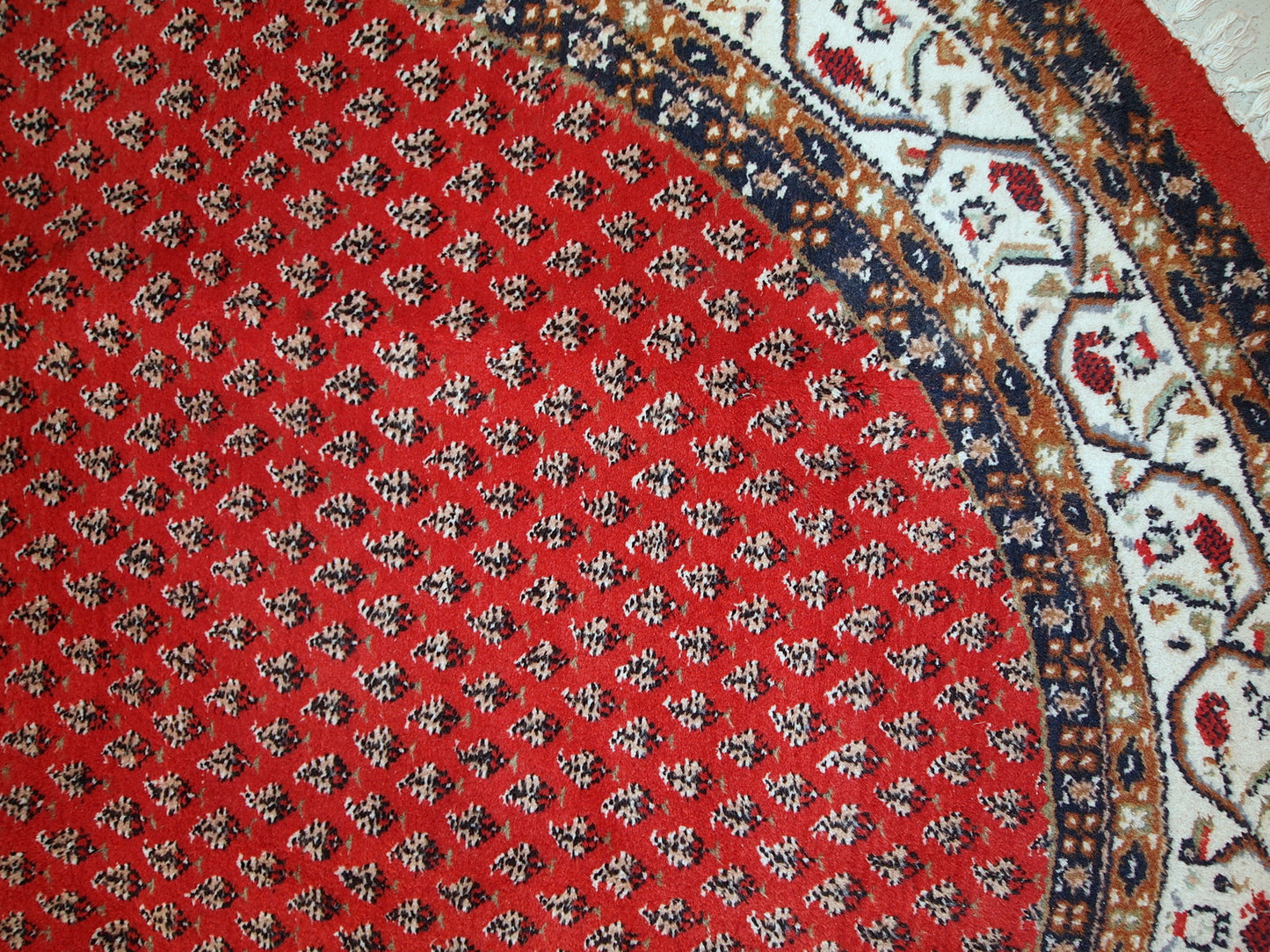 Vintage handmade Indian rug with Persian Seraband design in red with white border. All-over design with repeating pattern. The rug is from the end of 20th century in original good condition. 