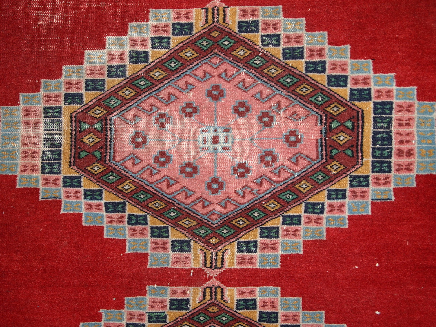 Handmade vintage Uzbek distressed rug in bright red wool. It has been made in the middle of 20th century in Central Asia.