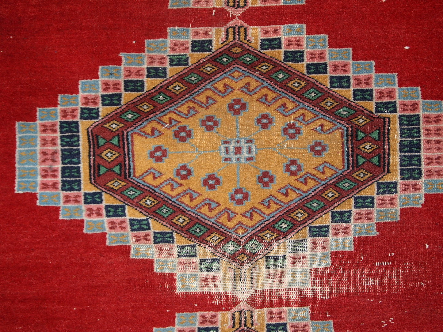 Handmade vintage Uzbek distressed rug in bright red wool. It has been made in the middle of 20th century in Central Asia.