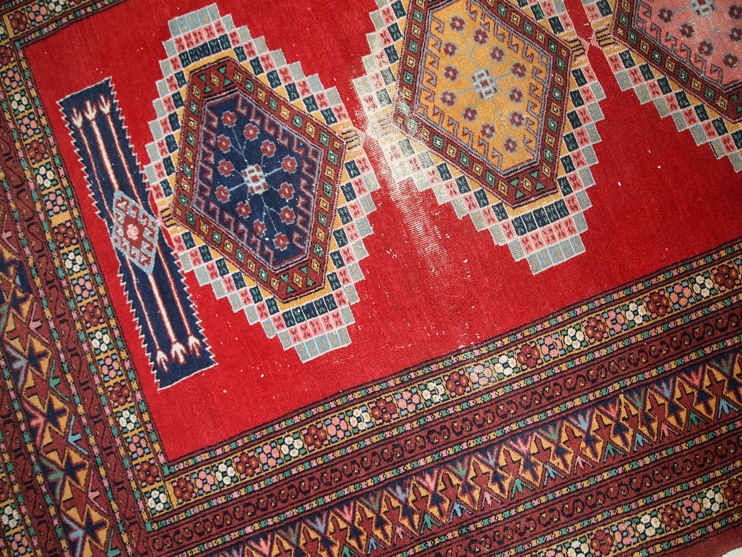 Handmade vintage Uzbek distressed rug in bright red wool. It has been made in the middle of 20th century in Central Asia.