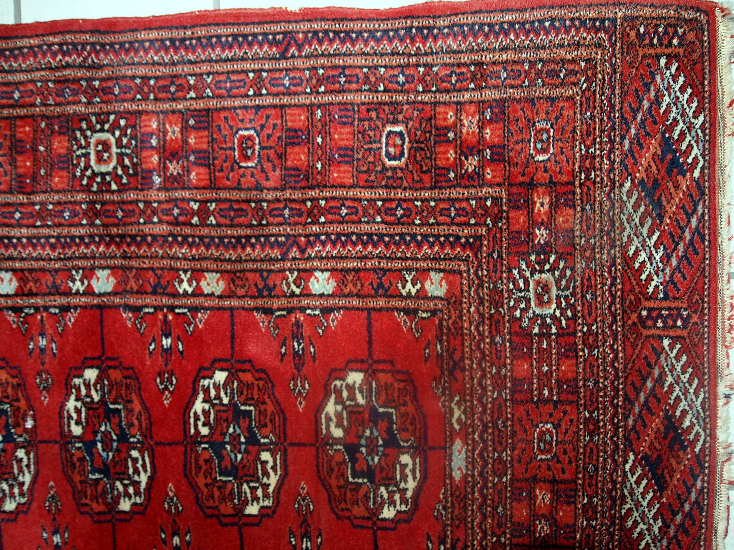 Vintage handmade Tekke rug from Turkmenistan in original good condition. It has been made in the end of 20th century in red wool.