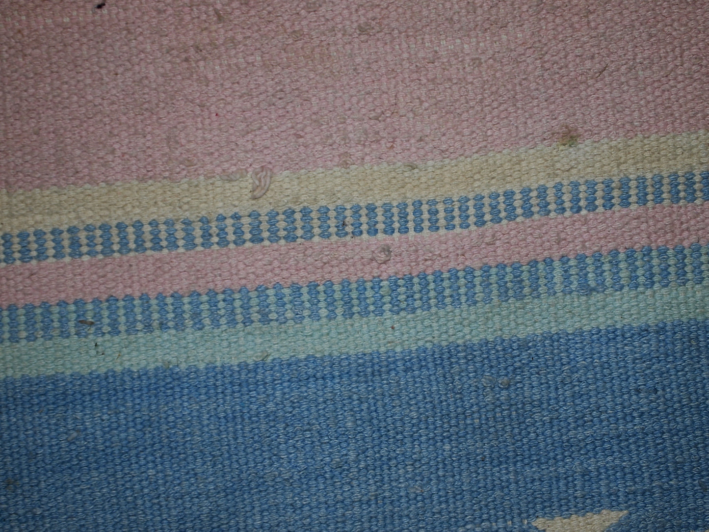 Close-up view of the kilim's delicate pastel blue and sea blue stripes.